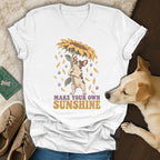 A white V-neck t-shirt featuring a graphic of a French bulldog holding a sunflower and the text Make Your Own Sunshine.