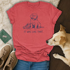 Red t-shirt with navy graphic of a puppy and a shoe, text "IT WAS LIKE THAT."