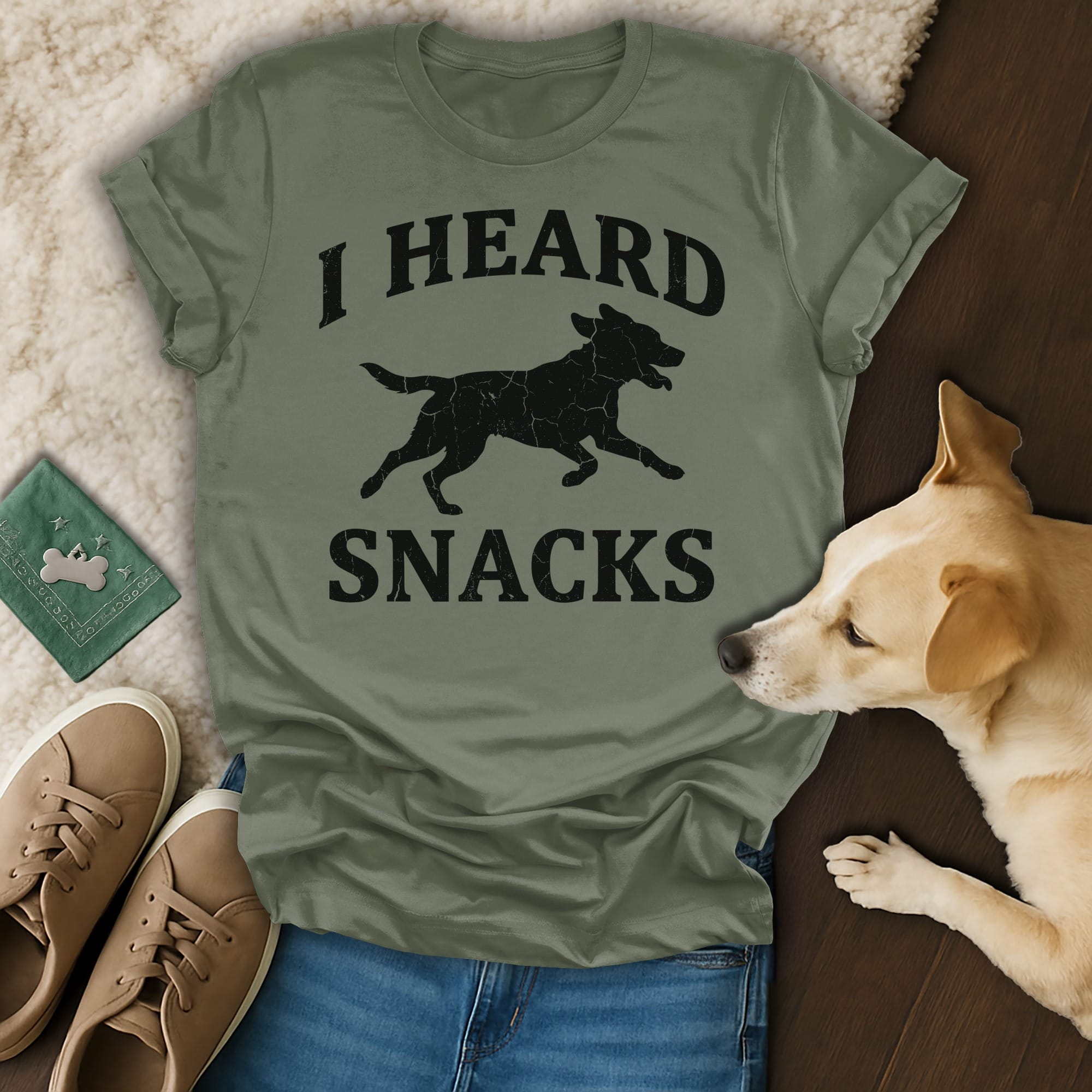 Green t-shirt with black text "I HEARD SNACKS" and a running dog graphic.
