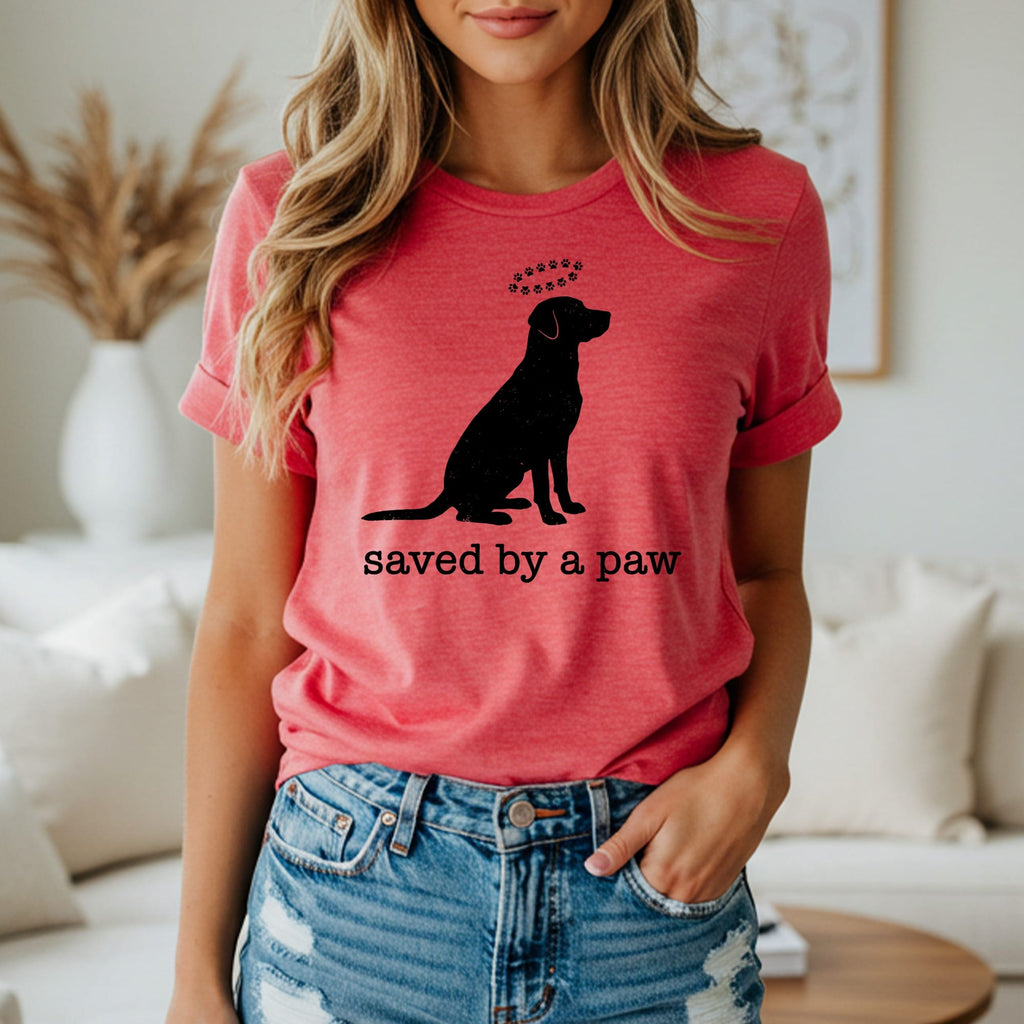 T-shirt with silhouette of a sitting dog and text "saved by a paw".