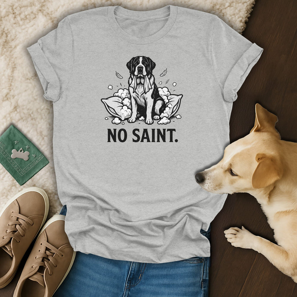 Grey t-shirt with black line art of a dog sitting on pillows, text "NO SAINT."