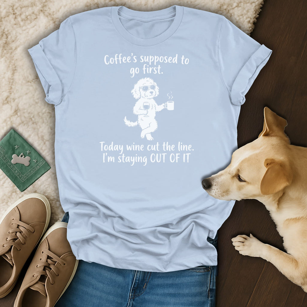 Light blue t-shirt with graphic of dog holding wine and coffee, text reads "Coffee's supposed to go first. Today wine cut the line. I'm staying OUT OF IT"