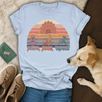 T-shirt with dogs in yoga poses against a sunset and lotus flower design.
