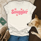 White t-shirt with pink "Snuggler" text and paw prints.