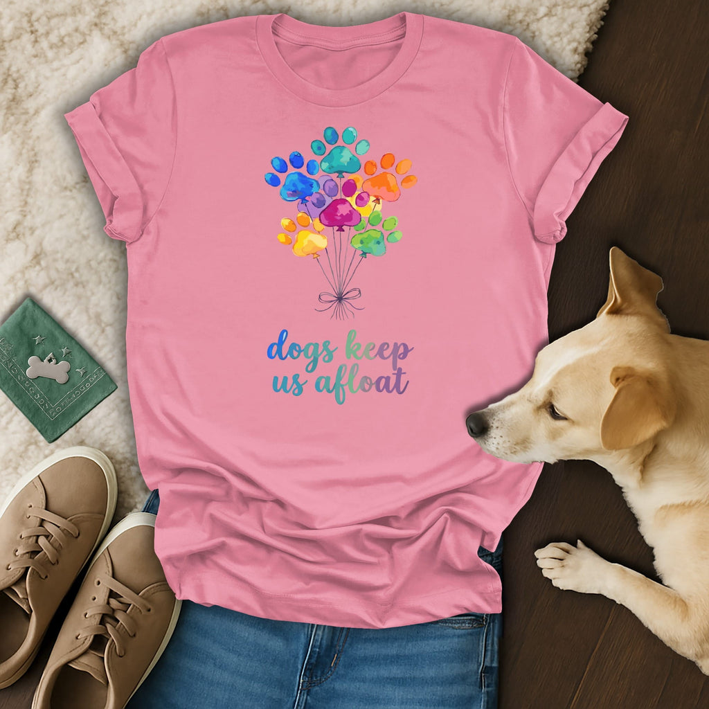 Pink t-shirt with colorful paw print balloons and text "dogs keep us afloat".