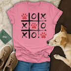Pink t-shirt with a tic-tac-toe game featuring paw prints, Os, and Xs.