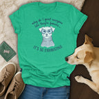Green t-shirt with illustration of a dog wearing glasses and a sweater, text says "why do I greet everyone like they're famous... IT'S SO EXHAUSTING".