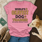 Pink t-shirt with "World's Okayest Dog Trainer" text and dog paw graphic.