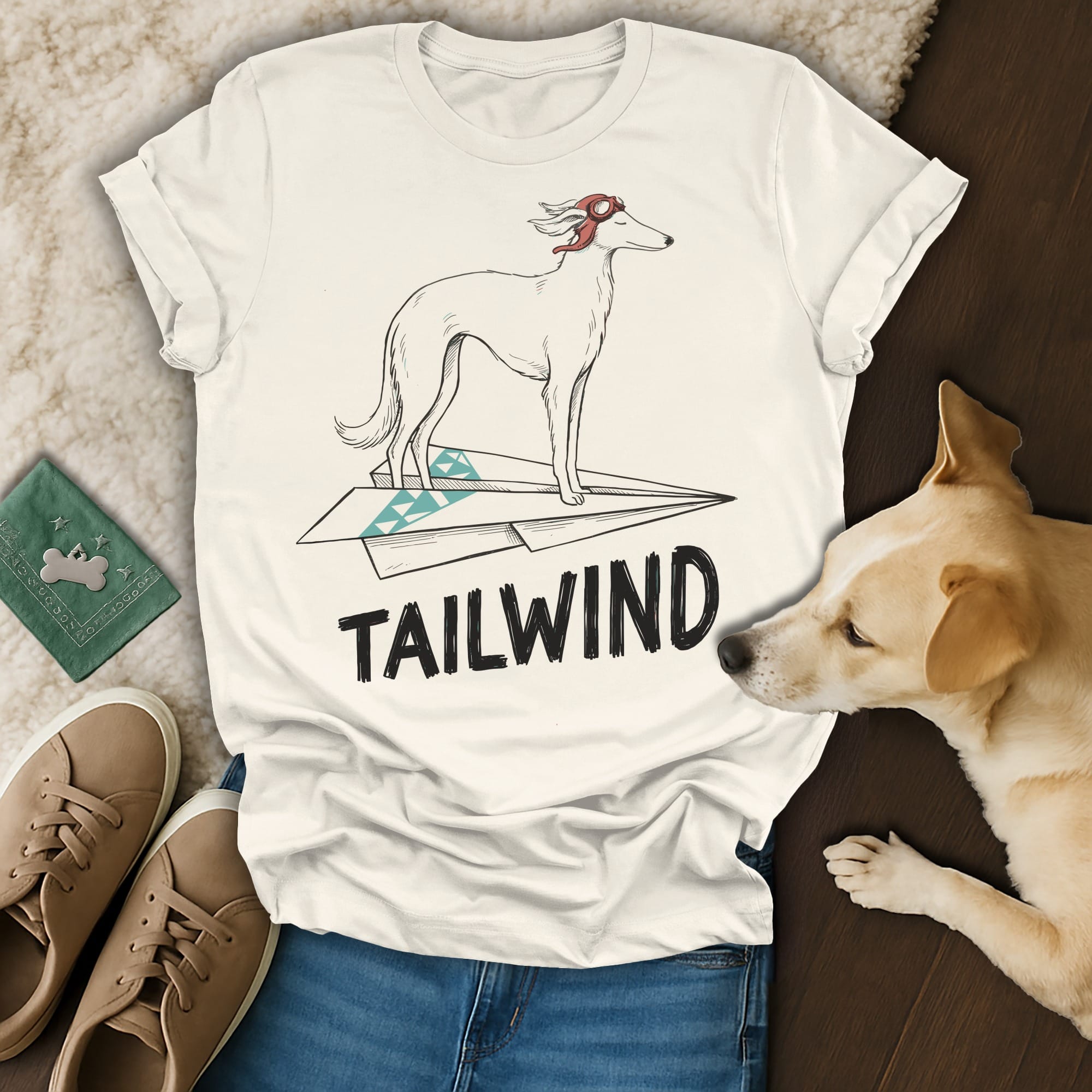 White t-shirt with a cartoon greyhound on a paper airplane, text "TAILWIND".