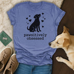 Blue t-shirt with black dog silhouette and "pawsitively obsessed" text.