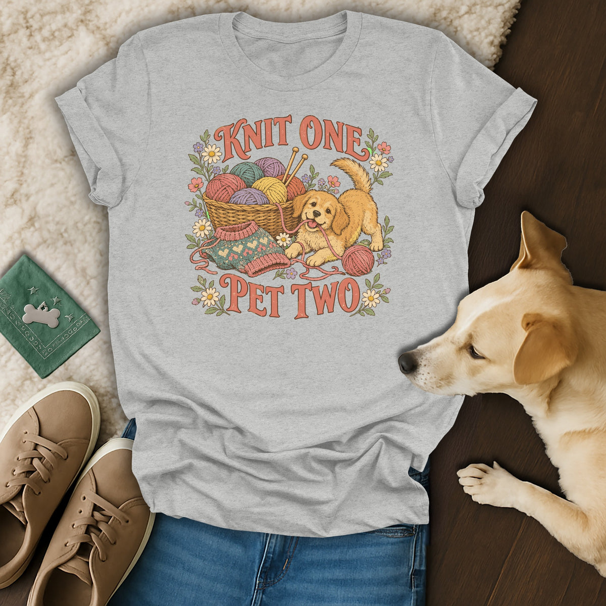 A gray t-shirt with a vintage illustration of a puppy and yarn, surrounded by a dog and shoes.