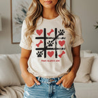 Cream t-shirt with tic-tac-toe game design and "Paws Always Win" text.