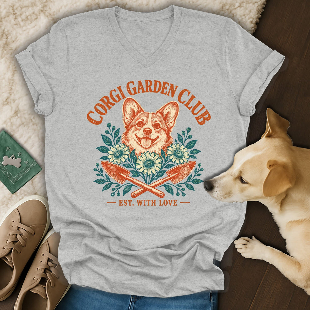 A gray V-neck t-shirt featuring a vintage Corgi Garden Club graphic with crossed trowels and flowers.
