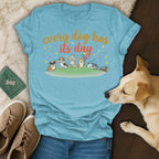 Light blue t-shirt with cartoon dogs and "every dog has its day" text.