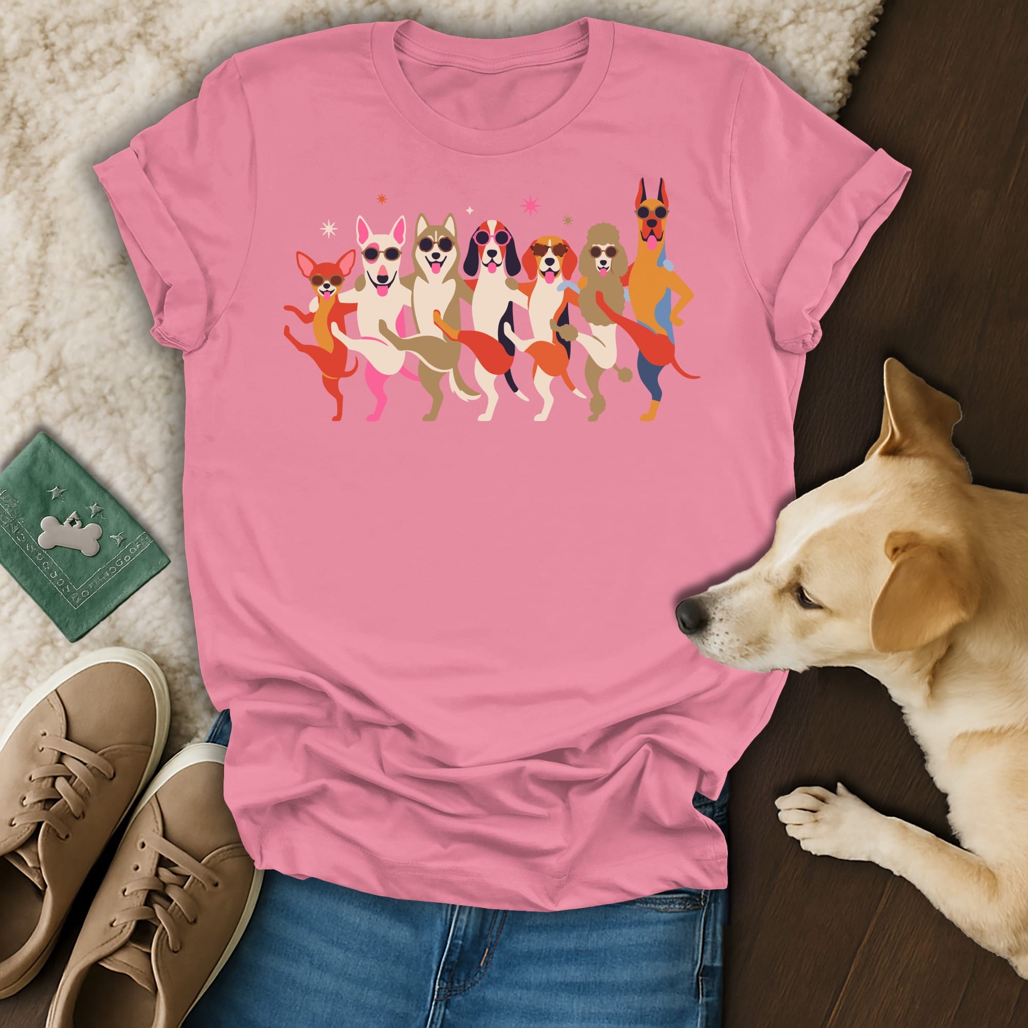 Pink t-shirt with colorful illustration of dancing dogs wearing sunglasses.