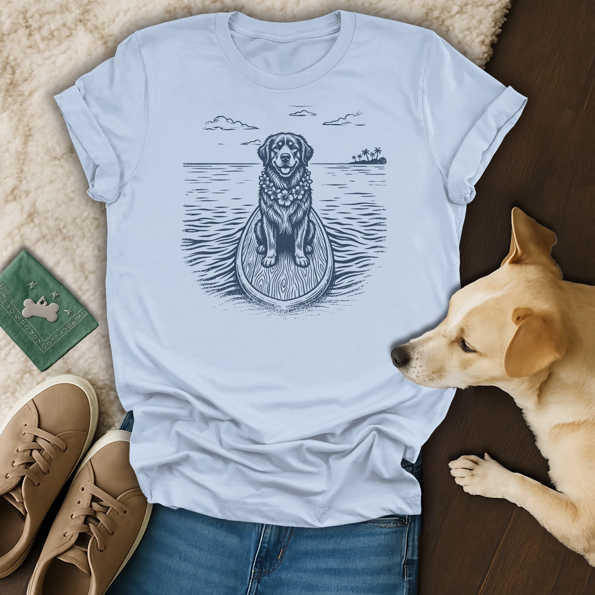 Graphic t-shirt with a dog on a surfboard, ocean, and palm trees.