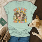 A light green t-shirt featuring a retro graphic of an older dog surrounded by flowers with the text "Gray Hair Don't Care."
