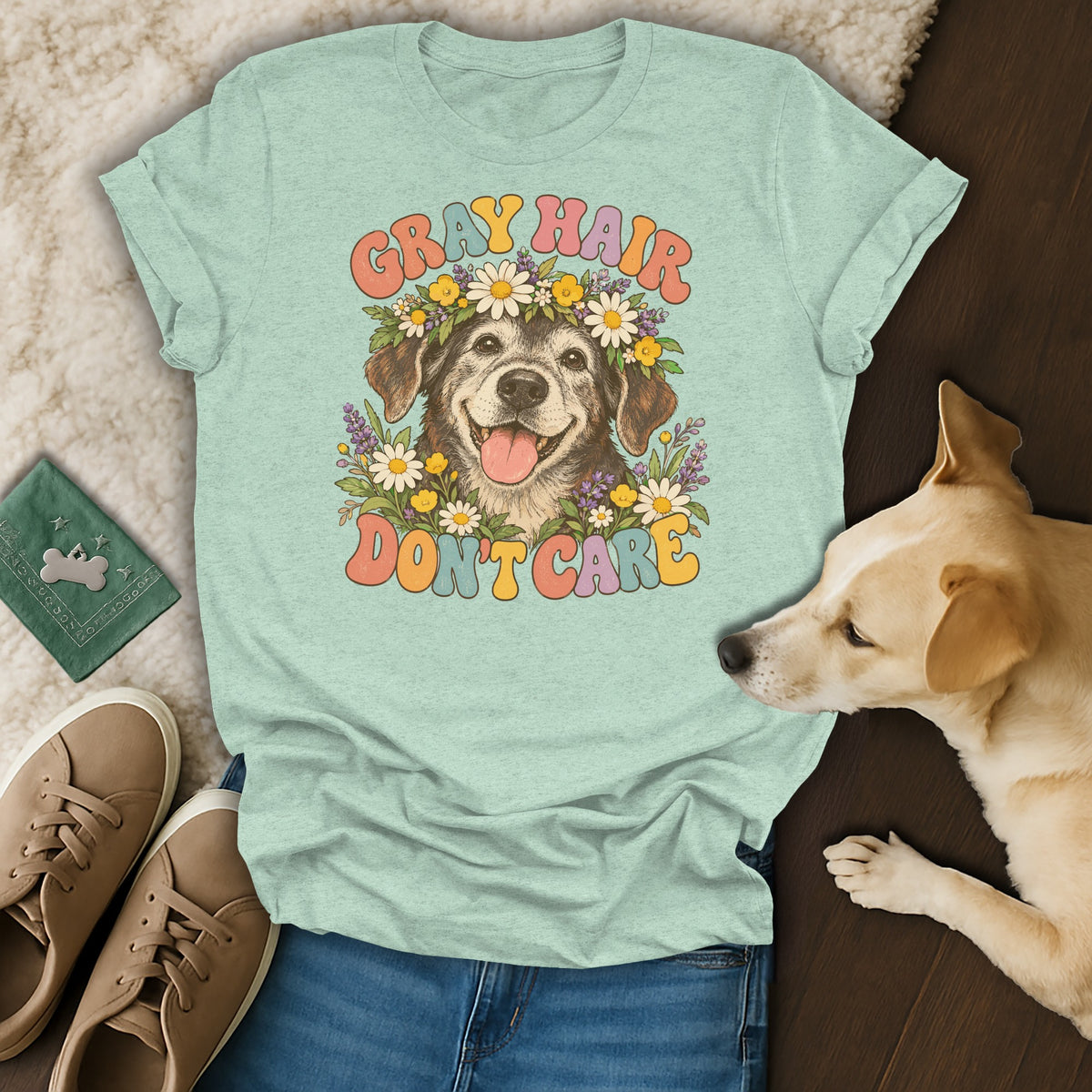 A light green t-shirt featuring a retro graphic of an older dog surrounded by flowers with the text "Gray Hair Don't Care."
