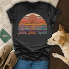 Black t-shirt with "paws, pose, repeat" text and sunset yoga dog graphic.