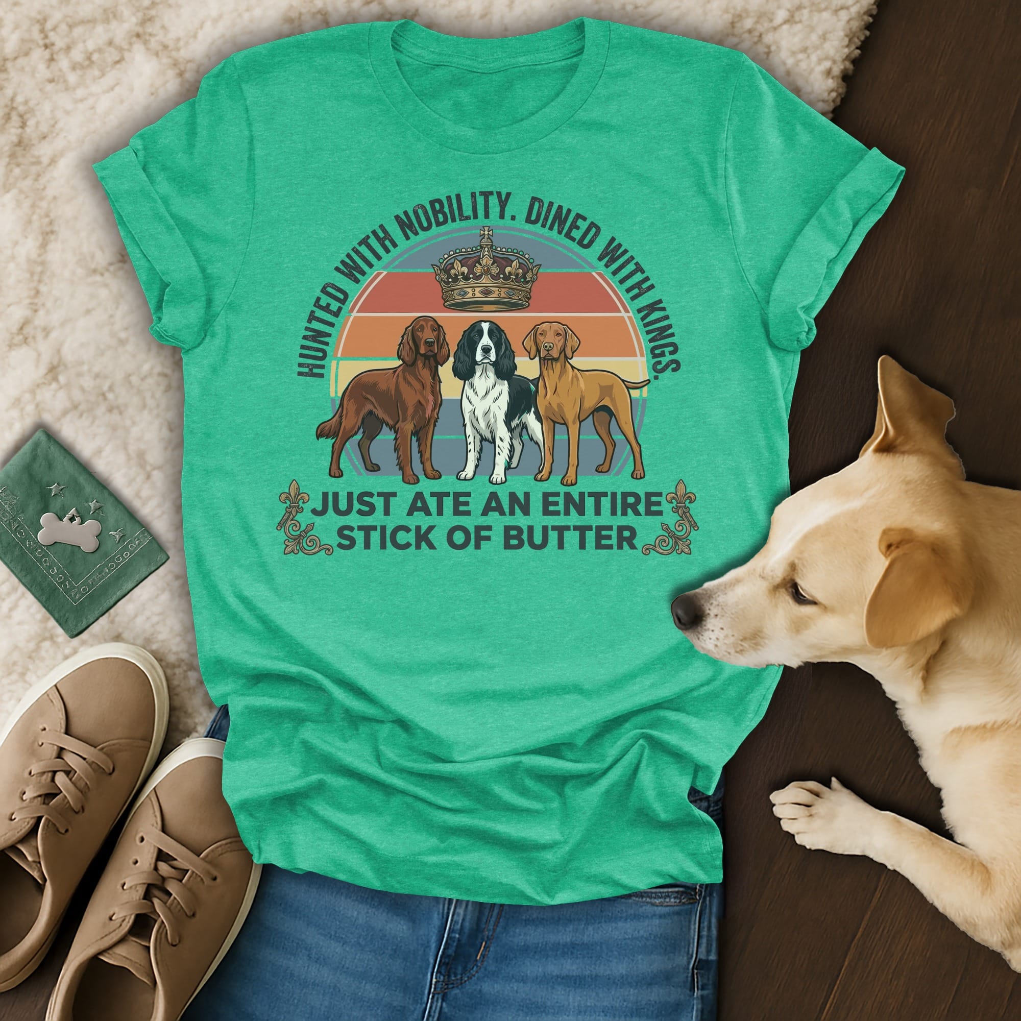 T-shirt with text "HUNTED WITH NOBILITY. DINED WITH KINGS. JUST ATE AN ENTIRE STICK OF BUTTER." featuring three dogs.