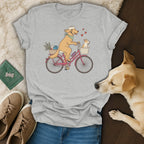 Grey t-shirt with dogs riding a bicycle, one carrying basket items.