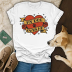White t-shirt with red heart, banner, and roses design reading "my dog owns me".