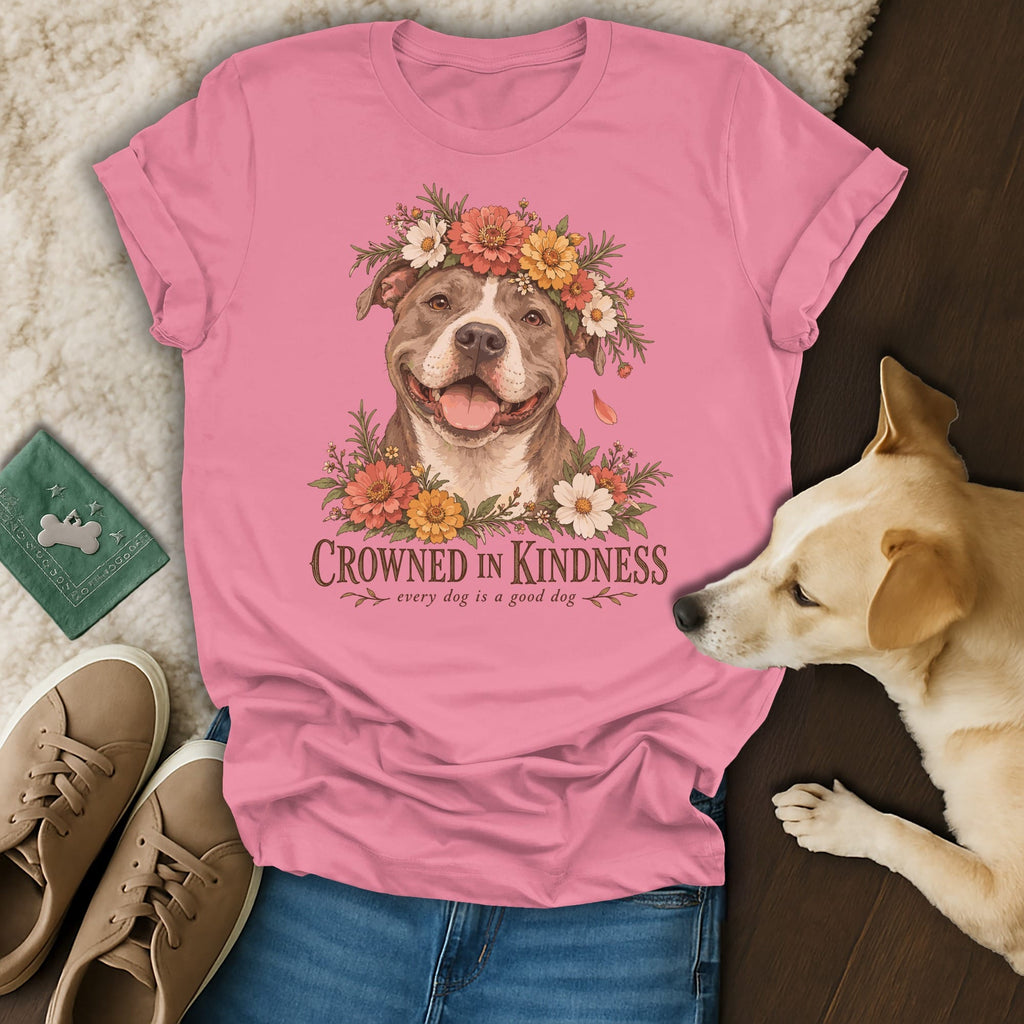 A pink t-shirt with a graphic of a pit bull wearing a flower crown and text reading "Crowned in Kindness."
