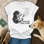 White t-shirt with dog blowing dandelion seeds, "Paws and Make a Wish" text.
