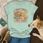 Light green t-shirt with a vintage illustration of a puppy, yarn, and the text Knit One Pet Two.
