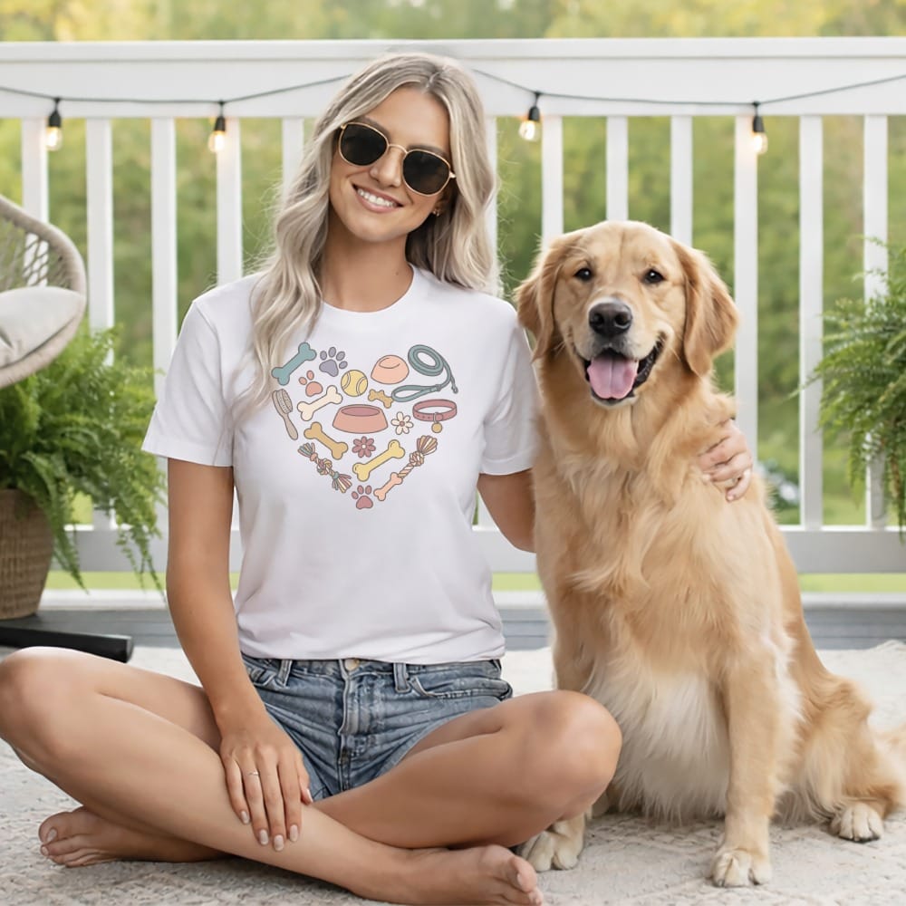 Woman with golden retriever wearing white t-shirt with heart design of dog accessories.