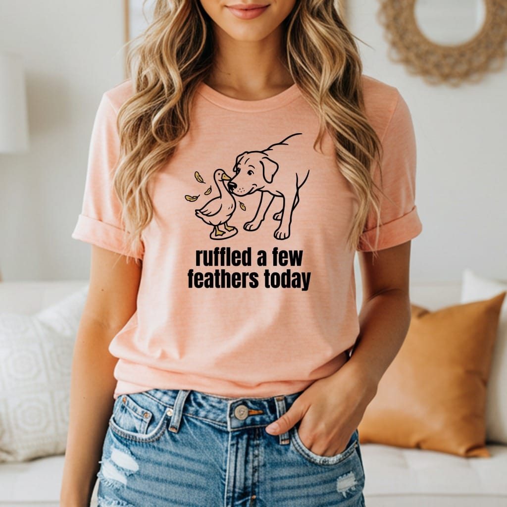 Peach t-shirt with line drawing of dog and duck; "ruffled a few feathers today" text.