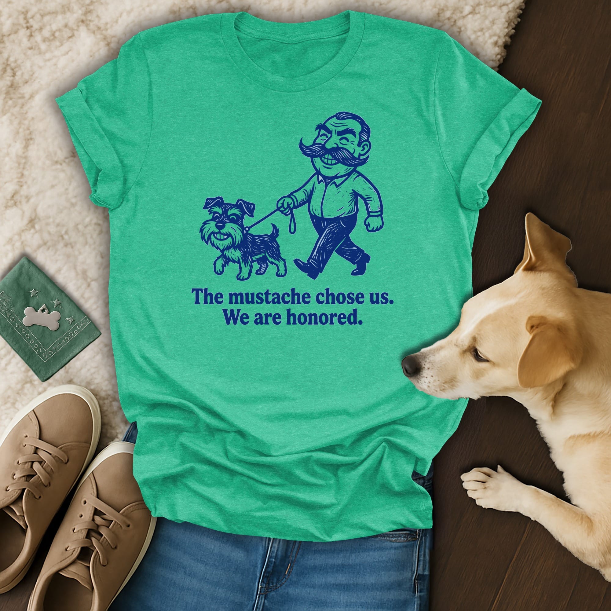 Green t-shirt with a cartoon man and dog, reads "The mustache chose us. We are honored."