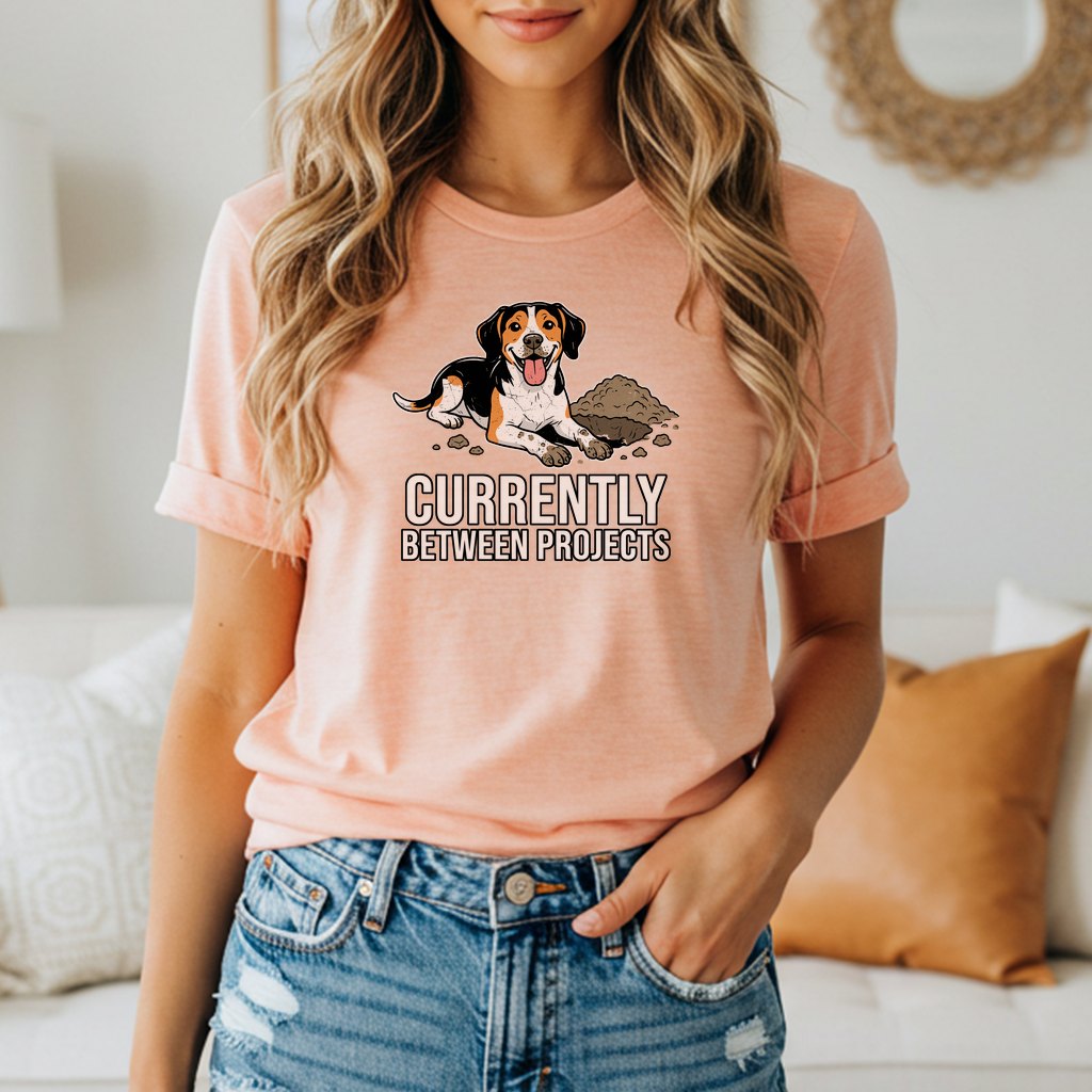T-shirt with a dog next to dirt pile and text "Currently Between Projects".
