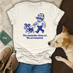 Cream t-shirt with a cartoon man and dog saying "The mustache chose us. We are honored."
