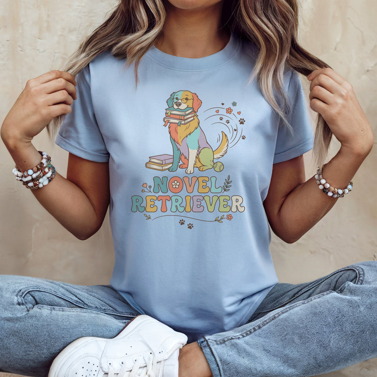 Light blue t-shirt with a colorful dog wearing glasses holding books.