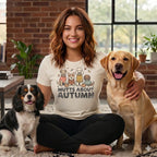Woman in "Mutts About Autumn" shirt with three dogs: a black and white spaniel, a Labrador, and a shih tzu.