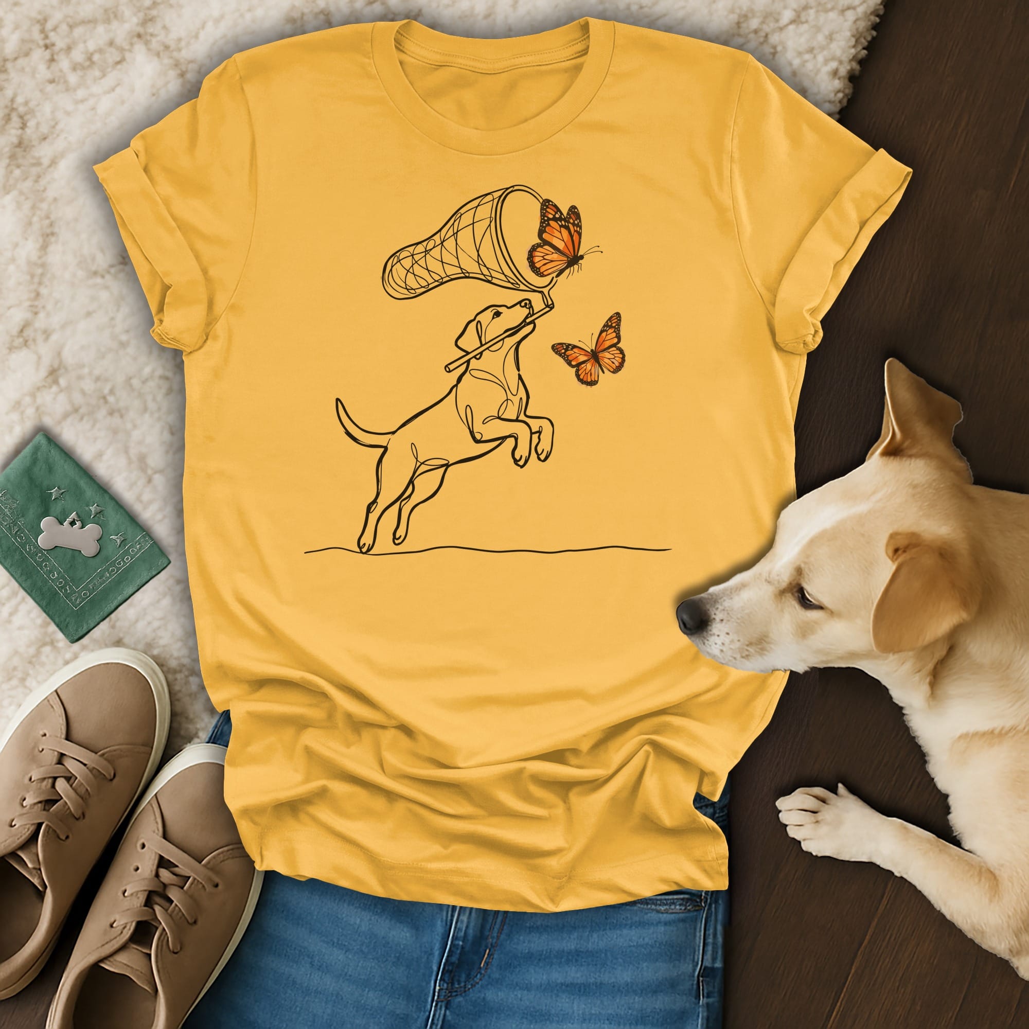 Yellow t-shirt with black line drawing of a dog catching butterflies.