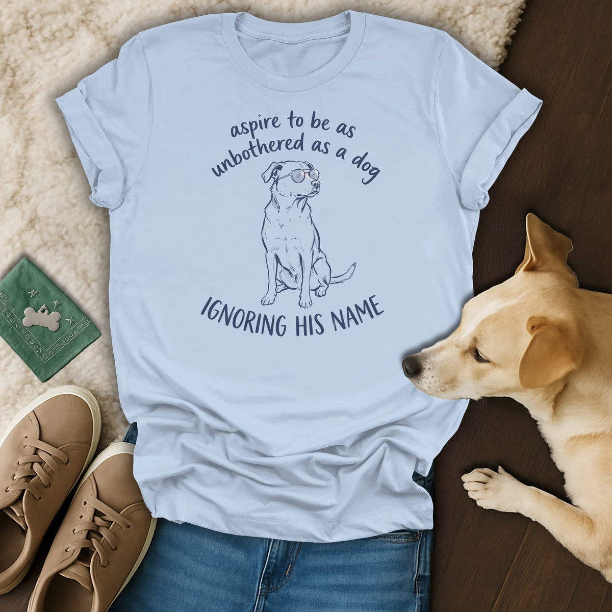 Light blue t-shirt with a dog wearing sunglasses and text "aspire to be as unbothered as a dog ignoring his name".