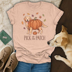 Golden retriever wearing a pumpkin costume on a peach t-shirt with "Pick of the Patch" text.
