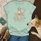 T-shirt with a colorful dog sitting on a quilt, text says "Quilty As Charged."