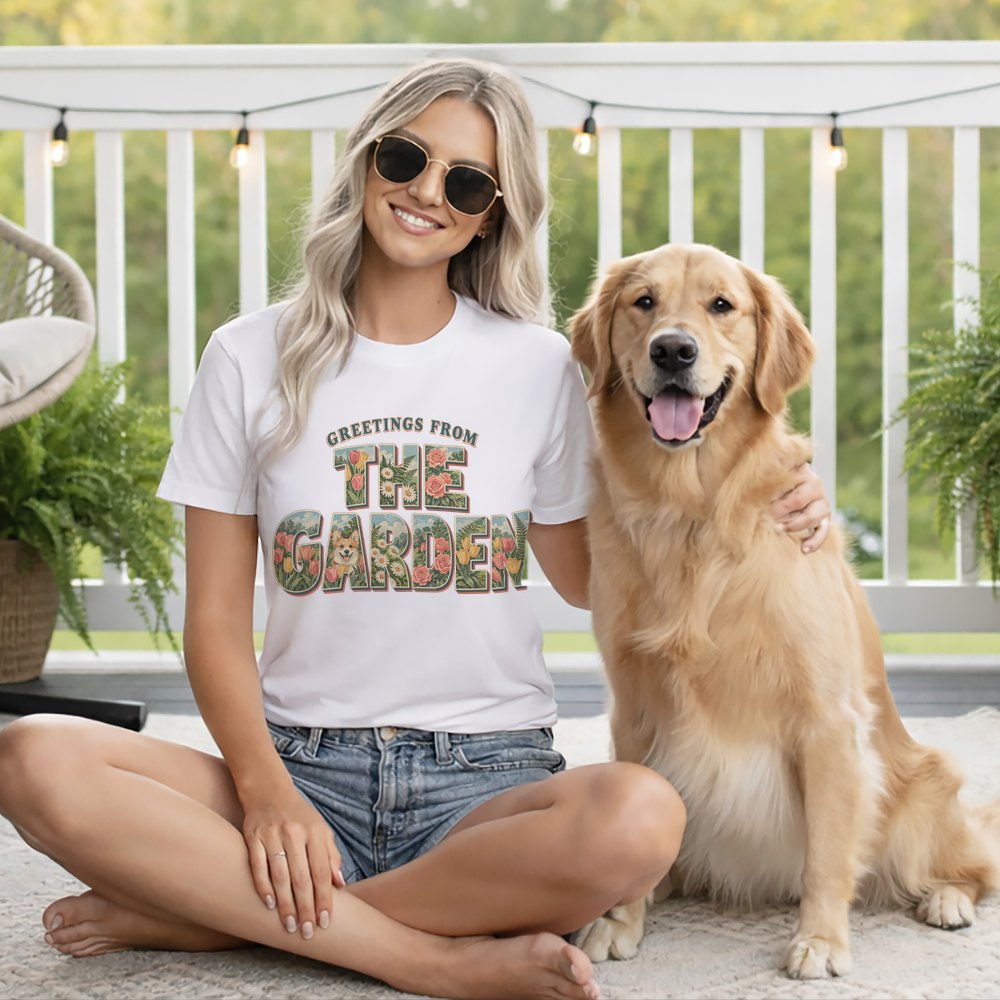 Blonde woman wearing sunglasses and a white graphic t-shirt sits outdoors beside a golden retriever.