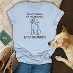 Light blue t-shirt with text "I'M NOT SAYING I'M THE FAVORITE BUT I'M THE FAVORITE" and a dog illustration.