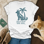 White t-shirt with teal dog and palm tree graphic and text.