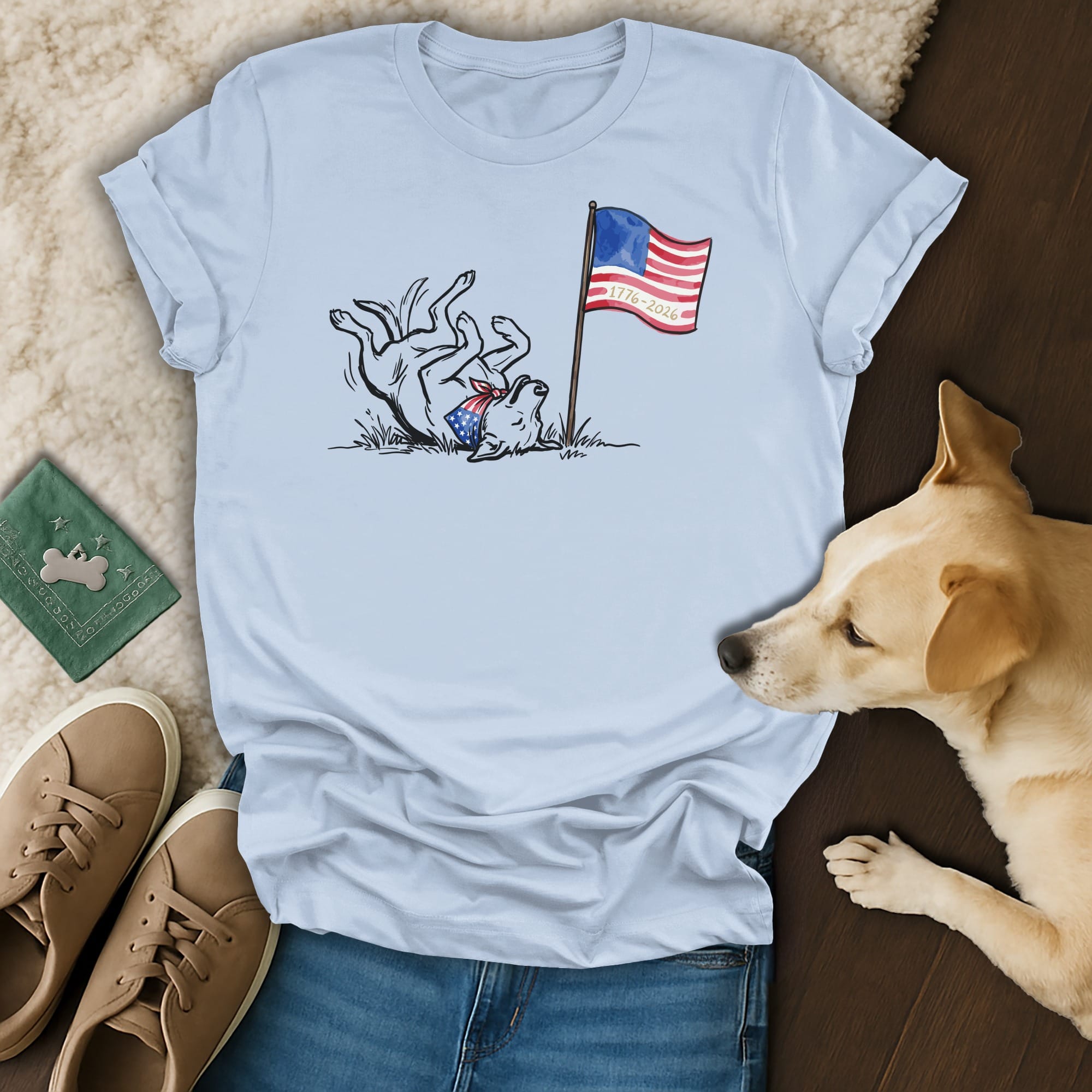 Light blue t-shirt with a dog celebrating the 4th of July with an American flag.