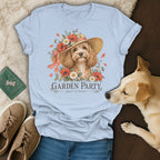 Light blue t-shirt featuring a graphic of a curly dog wearing a floral hat and the text GARDEN PARTY guest of honor.