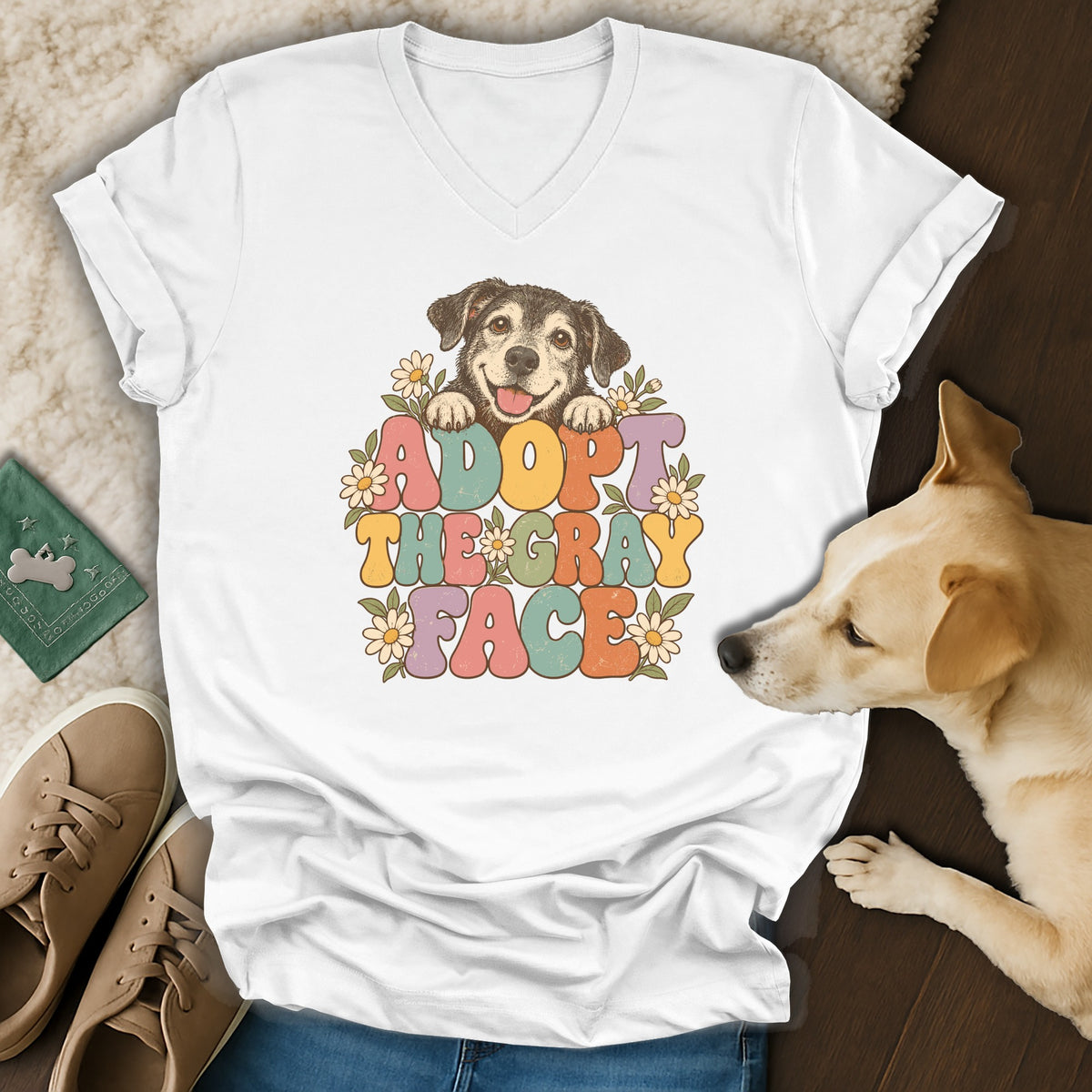White v-neck t-shirt featuring a retro graphic of a happy dog and the text ADOPT THE GRAY FACE.