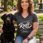 Woman and black lab sit on park bench, woman wears grey t-shirt with "Ruff Around and Find Out" text.