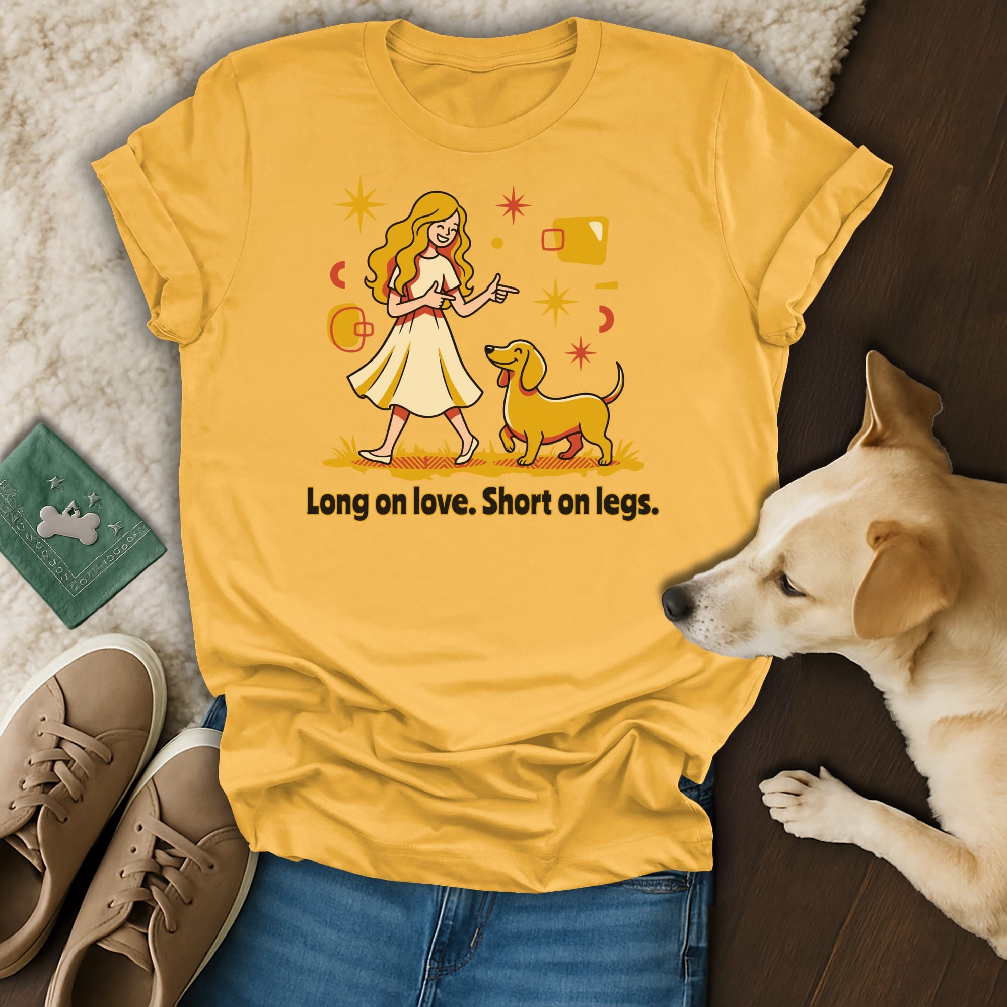 Yellow t-shirt with a cartoon dog and woman reading "Long on love. Short on legs."