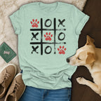 Light teal t-shirt with a tic-tac-toe grid featuring paw prints and Xs and Os.