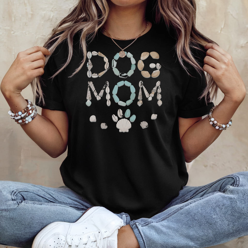 Black t-shirt with "DOG MOM" text in shells and a paw print.